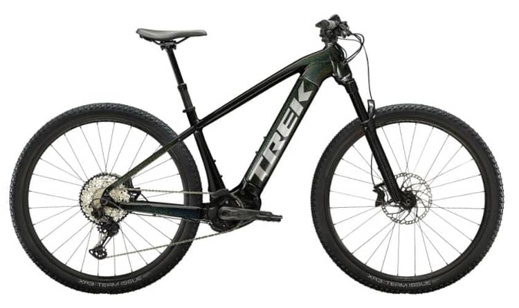 Trek mountain bike with teal and black frame, large tread tires, and gear system on white background.