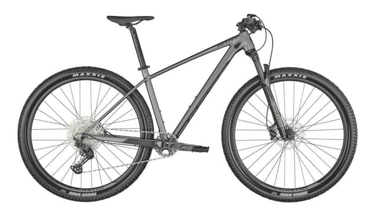 Gray Scale mountain bike with Maxxis tires, front suspension, and chain drive on a white background.