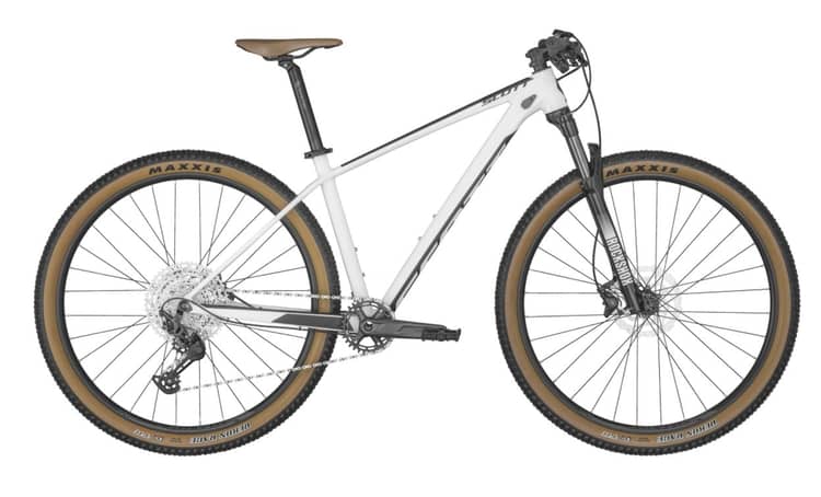 Gray Scale mountain bike with Maxxis tires, front suspension, and chain drive on a white background.