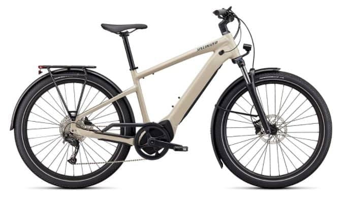 White Specialized Turbo Vado 3.0 electric bike with front suspension, fenders, and rear cargo rack.