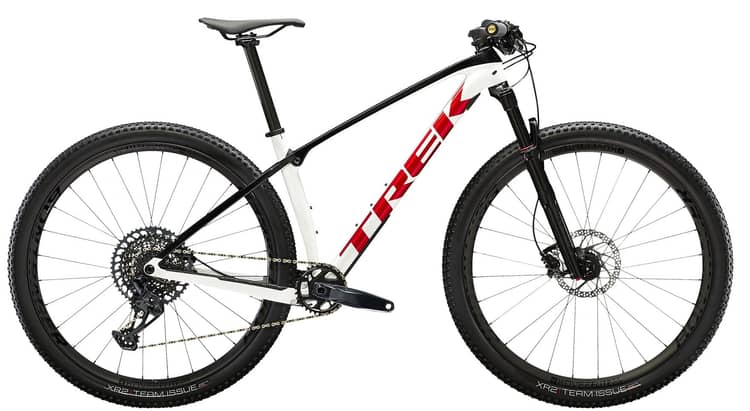 Blue Trek Procaliber 9.7 mountain bike with a carbon frame, large knobby tires, and a sophisticated gear system.
