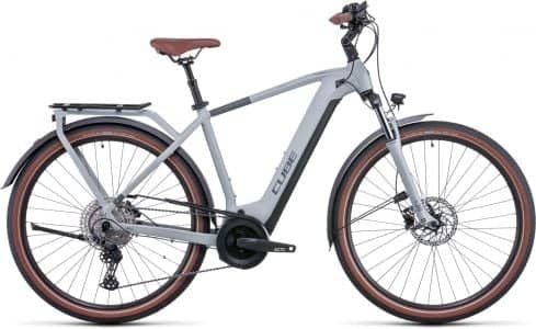 Modern grey Cube touring bicycle with tan saddle, disc brakes, and rear carrier on a white background.