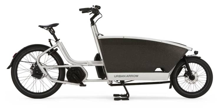 Silver Urban Arrow cargo bike with black box, electric assist, and kickstand on white background.