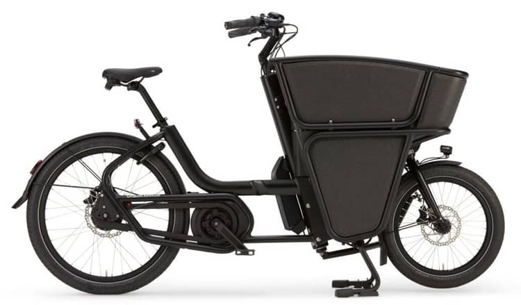 Black electric cargo bike with front basket, step-through frame, and sturdy kickstand on a white background.