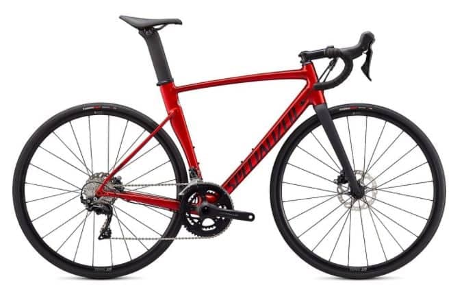 Red Specialized Allez road bike with disc brakes and black wheels, isolated on white background.