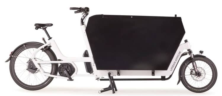 Cargo bike with large black box, named Urban Arrow, on kickstand, optimized for transport, from lease-a-bike.nl.