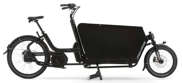 Electric black cargo bike with front cargo box and kickstand, labeled 'URBAN ARROW'.